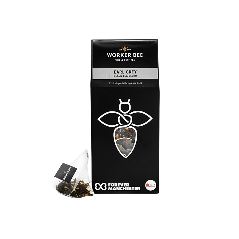 A black box of Worker Bee Tea & Coffee Earl Grey Whole Leaf Tea Sacks (15), made with Sri Lankan black tea and bergamot, displays a white bee logo. A single tea sack is placed in front; Forever Manchester logo appears at the bottom.