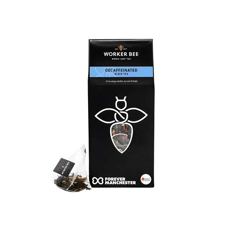 A black box of Worker Bee Tea & Coffee Decaffeinated Tea Sacks (15), made with premium Sri Lankan tea, featuring a white bee logo, a visible pyramid tea bag, and the Forever Manchester logo at the bottom.