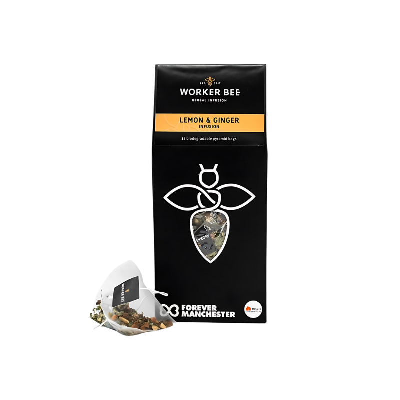 A black box of Worker Bee Tea & Coffee Lemon and Ginger Tea Sacks (15), featuring a white bee logo, yellow label, and biodegradable pyramid bags. This caffeine-free herbal infusion supports Forever Manchester.