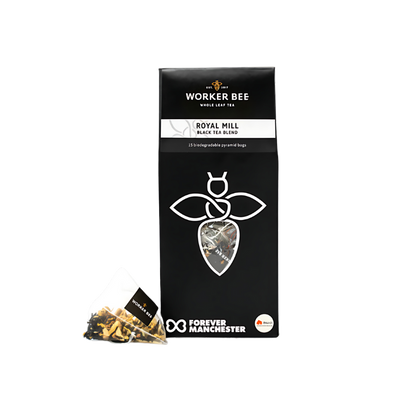 A black pack of Worker Bee Tea & Coffee Royal Mill Whole Leaf Tea Sacks (15) with a bee logo is shown. A pyramid tea bag displaying loose tea is in front. The Forever Manchester logo appears on the packaging.