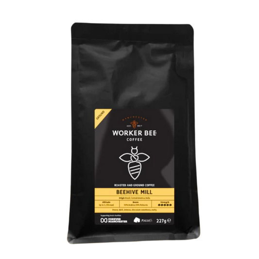 A 227g black bag of Worker Bee Tea & Coffee, labeled Beehive Mill Ground for Cafetierre & Filter, features yellow and black accents, a bee icon, and contains Brazilian Arabica coffee roasted and ground.