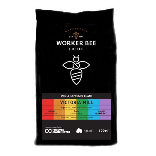 Black coffee bag with 'Worker Bee Coffee' rainbow branding and product details on a white background