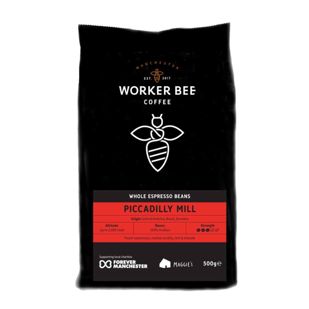 A 500g bag of Worker Bee Tea & Coffee Piccadilly Mill Espresso Beans, whole bean, with origin and strength info, chocolatey notes, a bee logo on black packaging, and support for Forever Manchester.