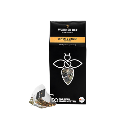 A black box of Worker Bee Tea & Coffee Lemon and Ginger Tea Sacks (15), featuring a white bee logo, yellow label, and biodegradable pyramid bags. This caffeine-free herbal infusion supports Forever Manchester.